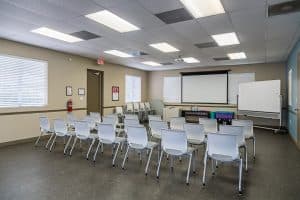 rows of chairs in room with projector screen