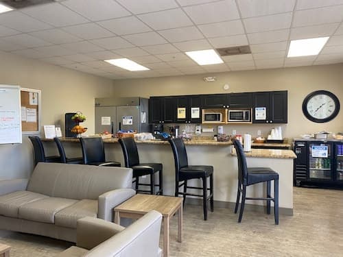 rehab kitchen with barstools cabinets and a couch