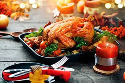 Thanksgiving dinner, Thanksgiving turkey. Served table. Thanksgiving table served with turkey, decorated with bright autumn leaves. Roasted turkey, table setting