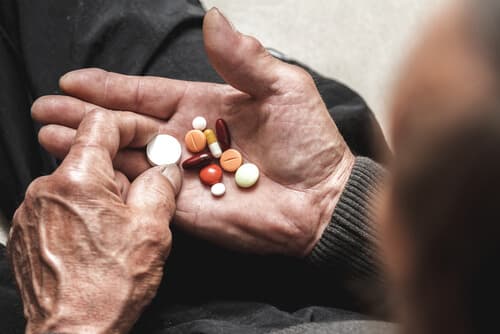 Elderly person taking pills for health